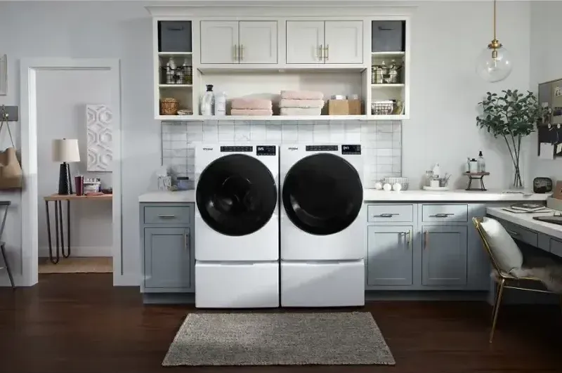 A washer and dryer right next to each other in someone's laundry room whose about to have the dryer vent cleaned out.